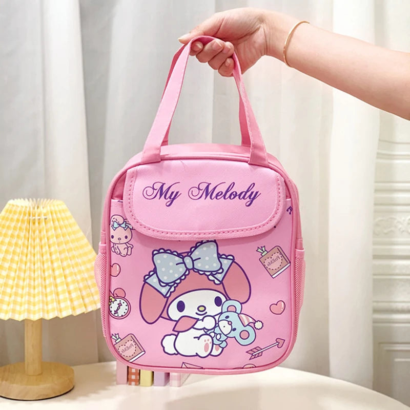 Pink 'My Melody' lunch bag held by a hand with a lamp and curtain in the background