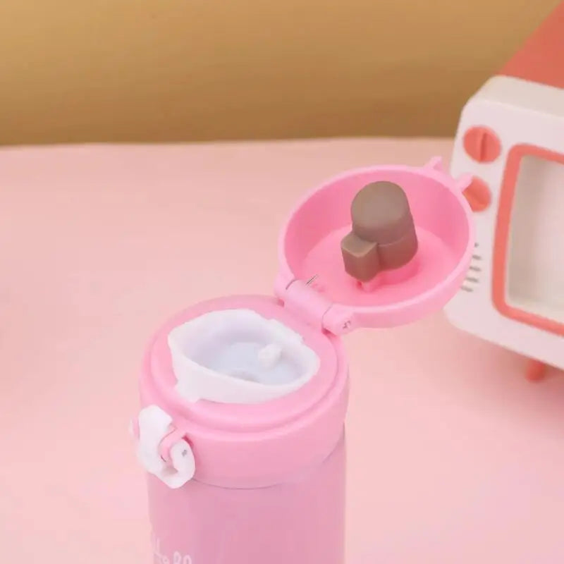 Pink toy with a small brown figure inside on a pink background