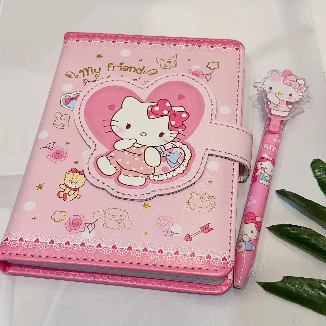 Pink Hello Kitty notebook with a matching pen on a white background