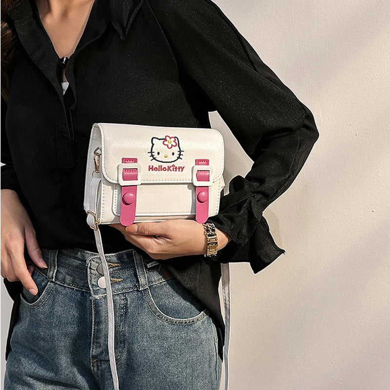 Person holding a white and pink Hello Kitty bag against a neutral background