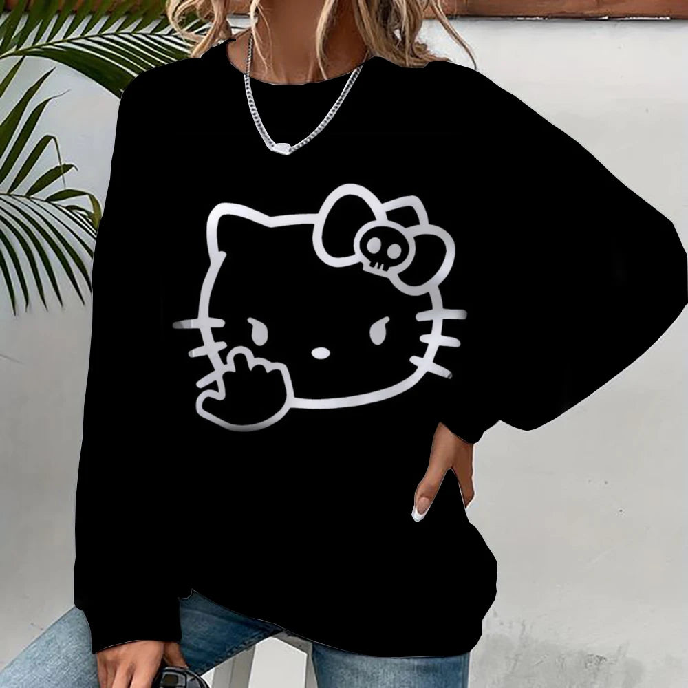 Person wearing a black sweatshirt with a white cat face design, sitting against a light-colored wall.