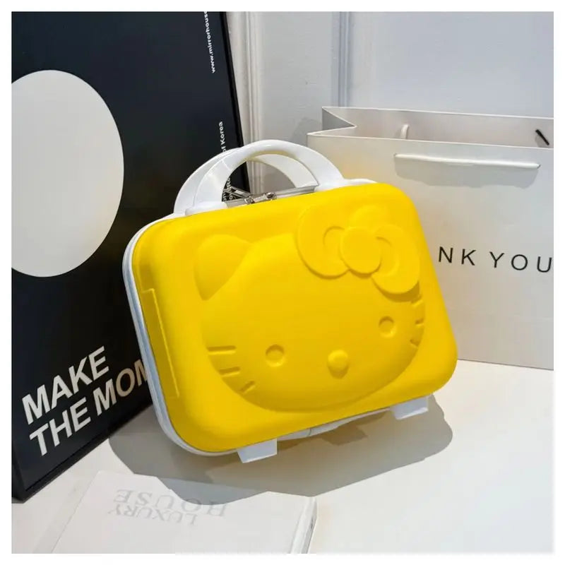 Yellow Hello Kitty lunch box on a white surface with a black and white sign in the background.