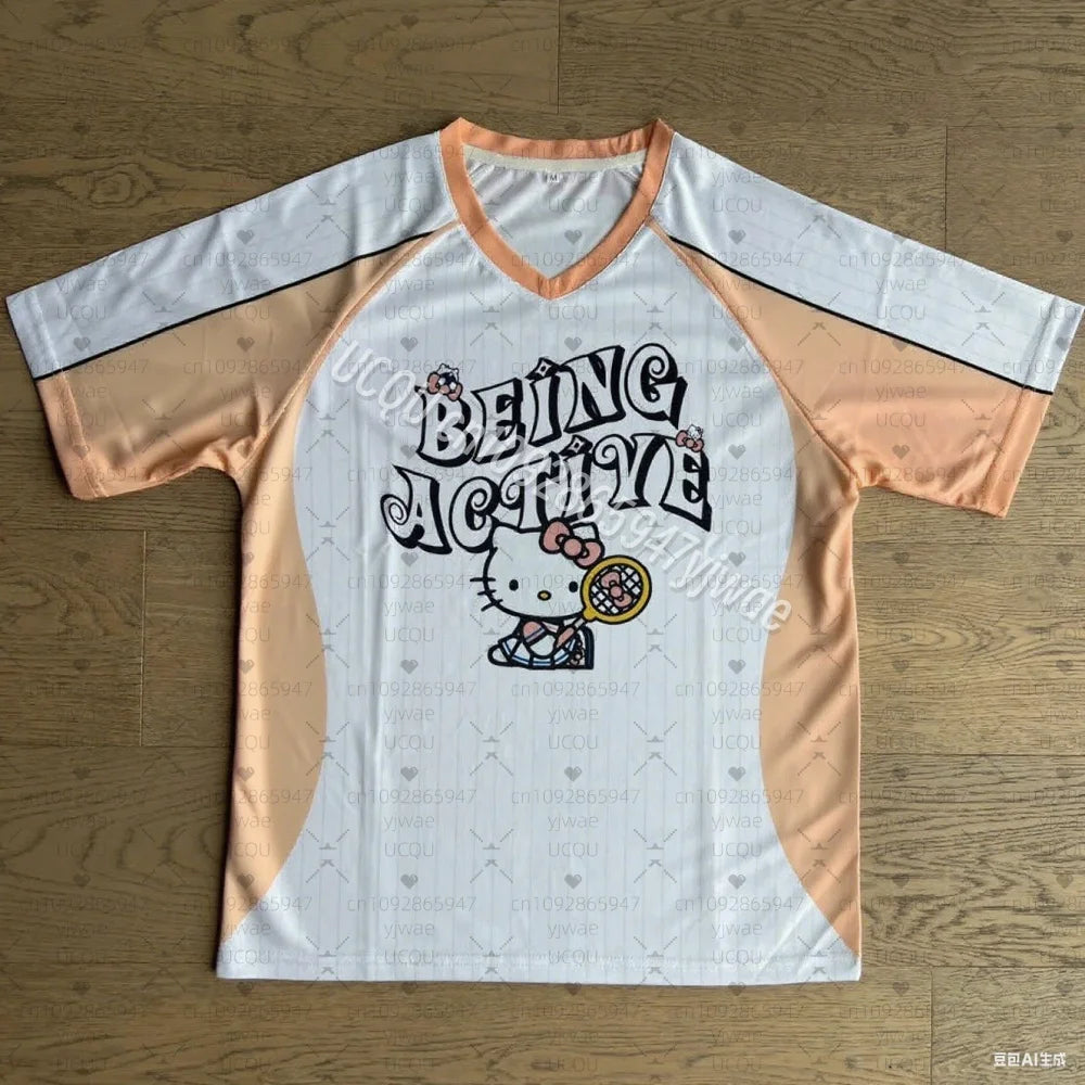 Baseball-style shirt with 'Being Active' text and Hello Kitty graphic on a wooden surface