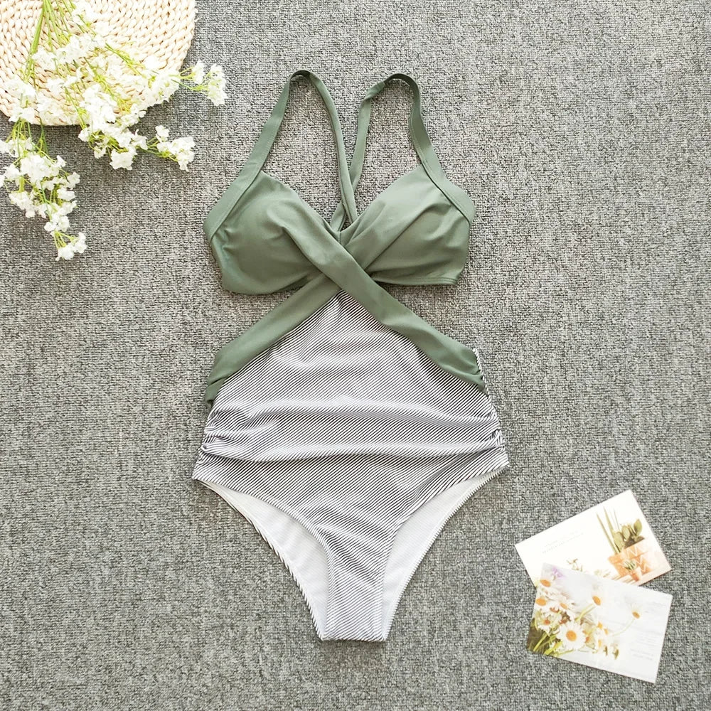 Green and gray swimsuit on a textured surface with flowers and cards.