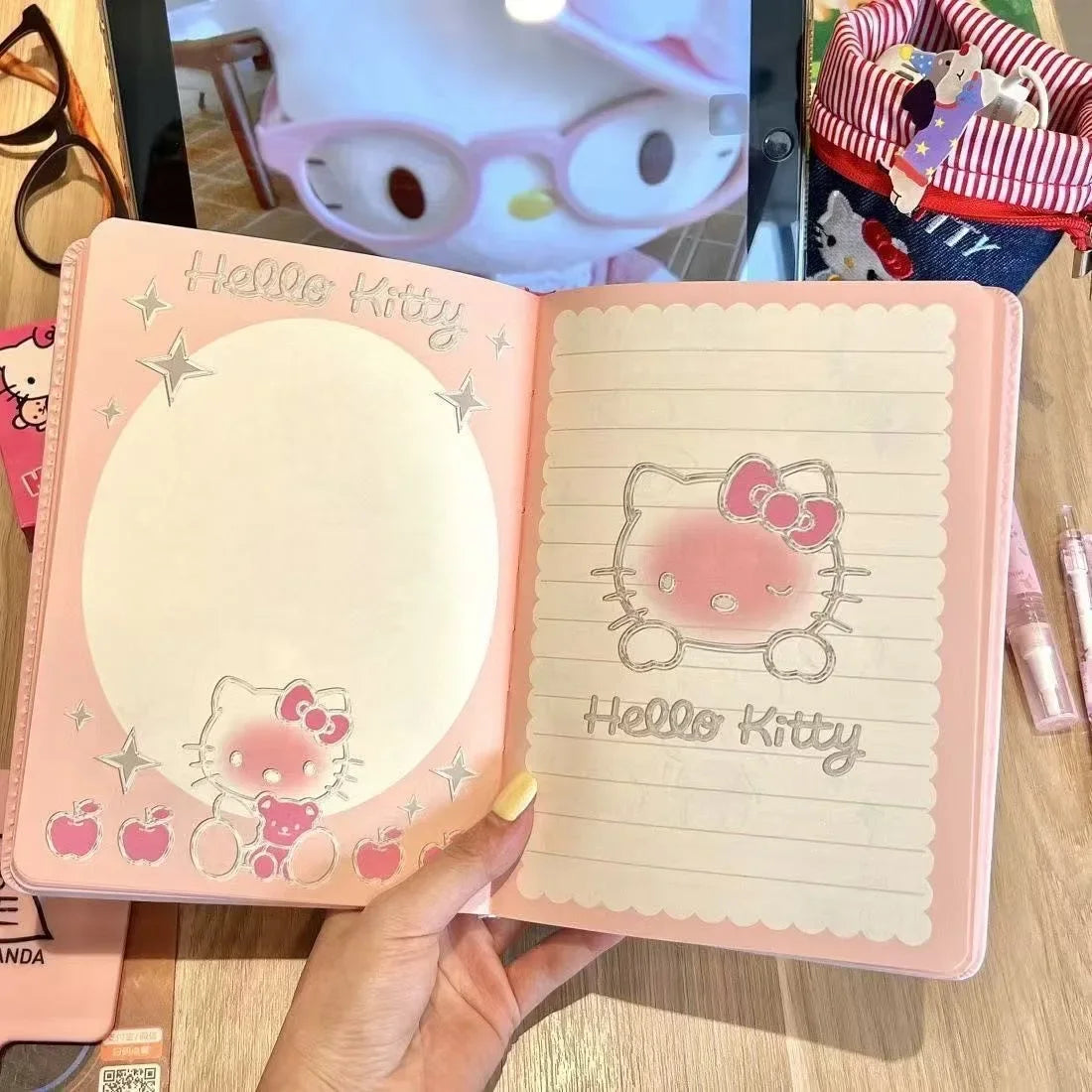 Hello Kitty notebook with a mirror on a wooden surface