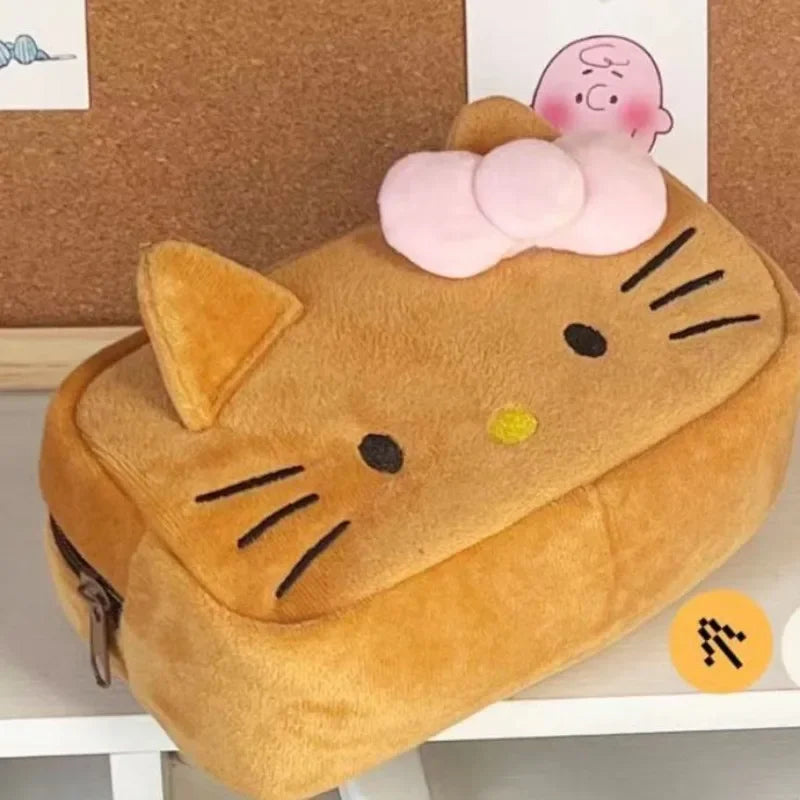 Plush cat-shaped pencil case with a pink bow on a white surface.