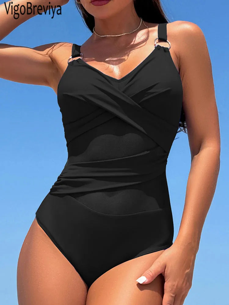 Woman wearing a black swimsuit against a clear blue sky