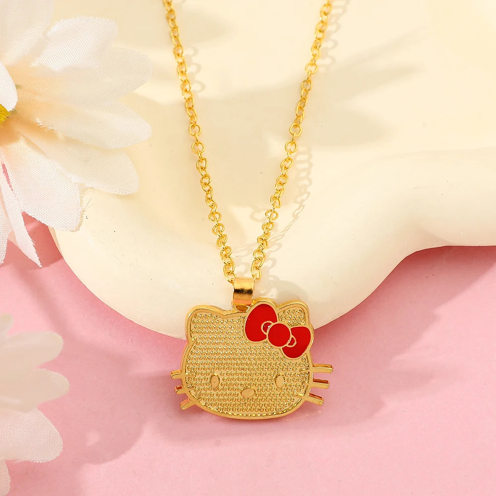 Gold Hello Kitty pendant necklace on a soft pink background with flowers.