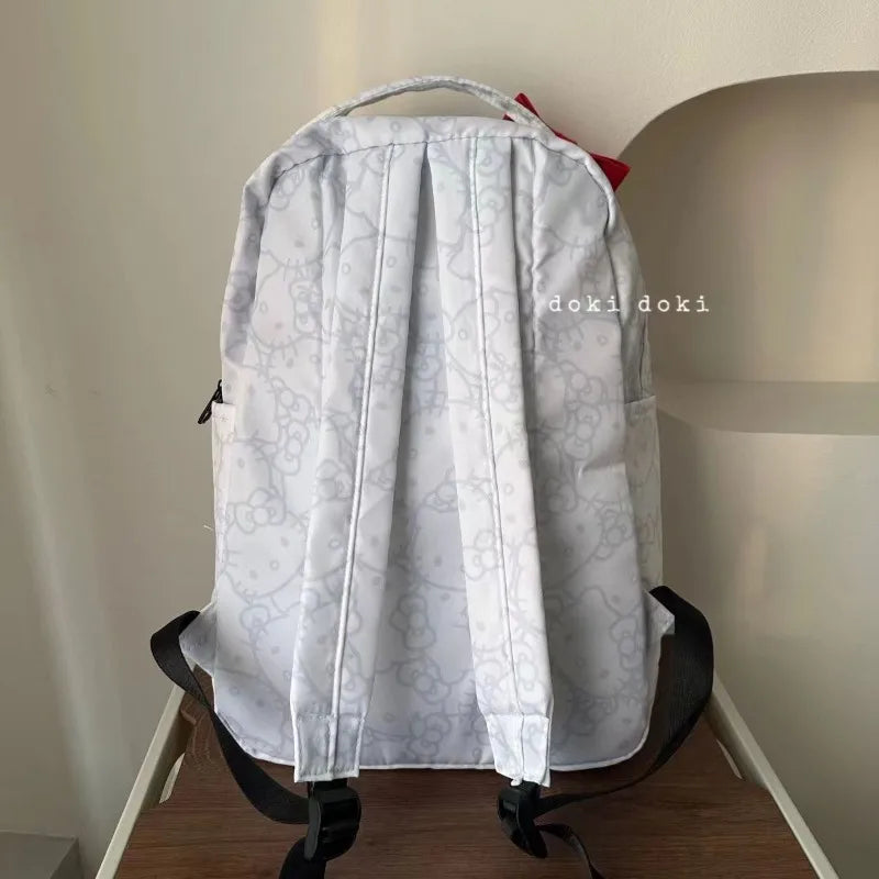 Light gray backpack with floral pattern on a chair against a plain wall.