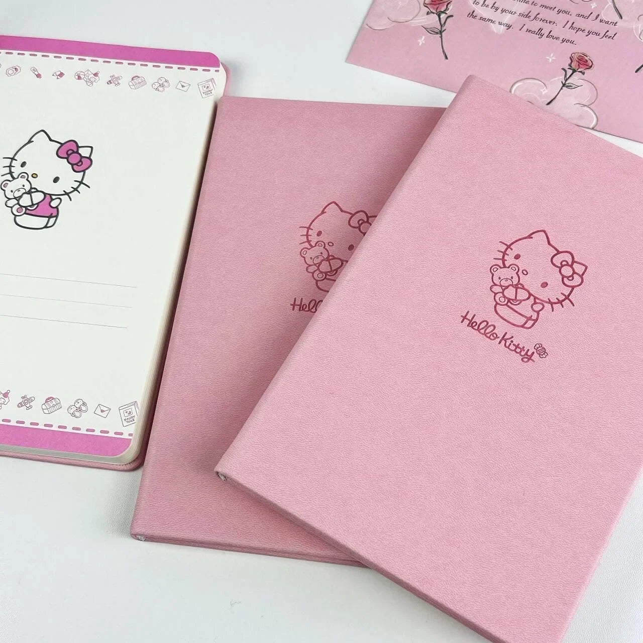 Pink notebooks with Hello Kitty design on a white background