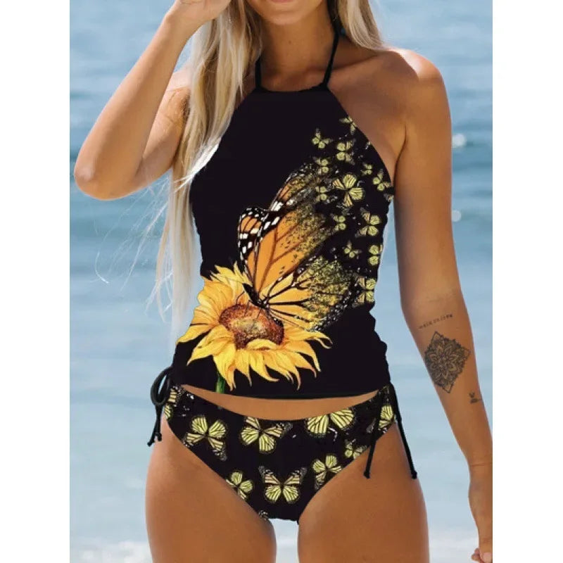 Woman wearing a black bikini with sunflower and butterfly design against a blue water background