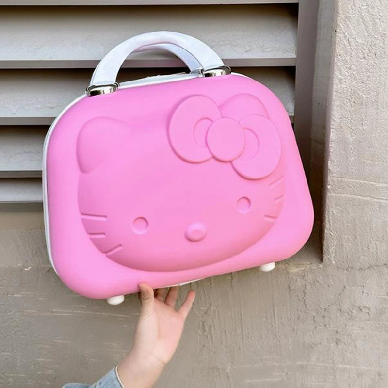 Pink Hello Kitty lunch box held by a hand against a neutral wall.