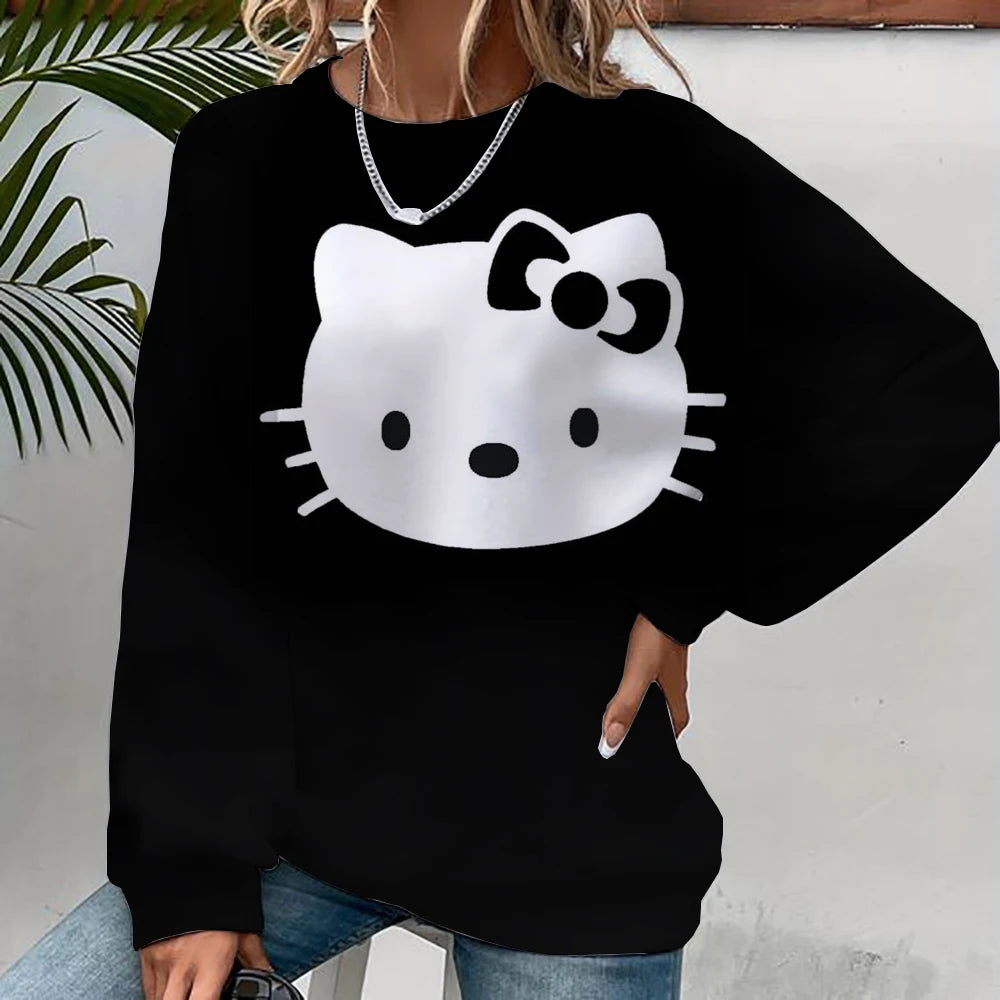 Black sweatshirt with a white cat face design worn by a person against a light background