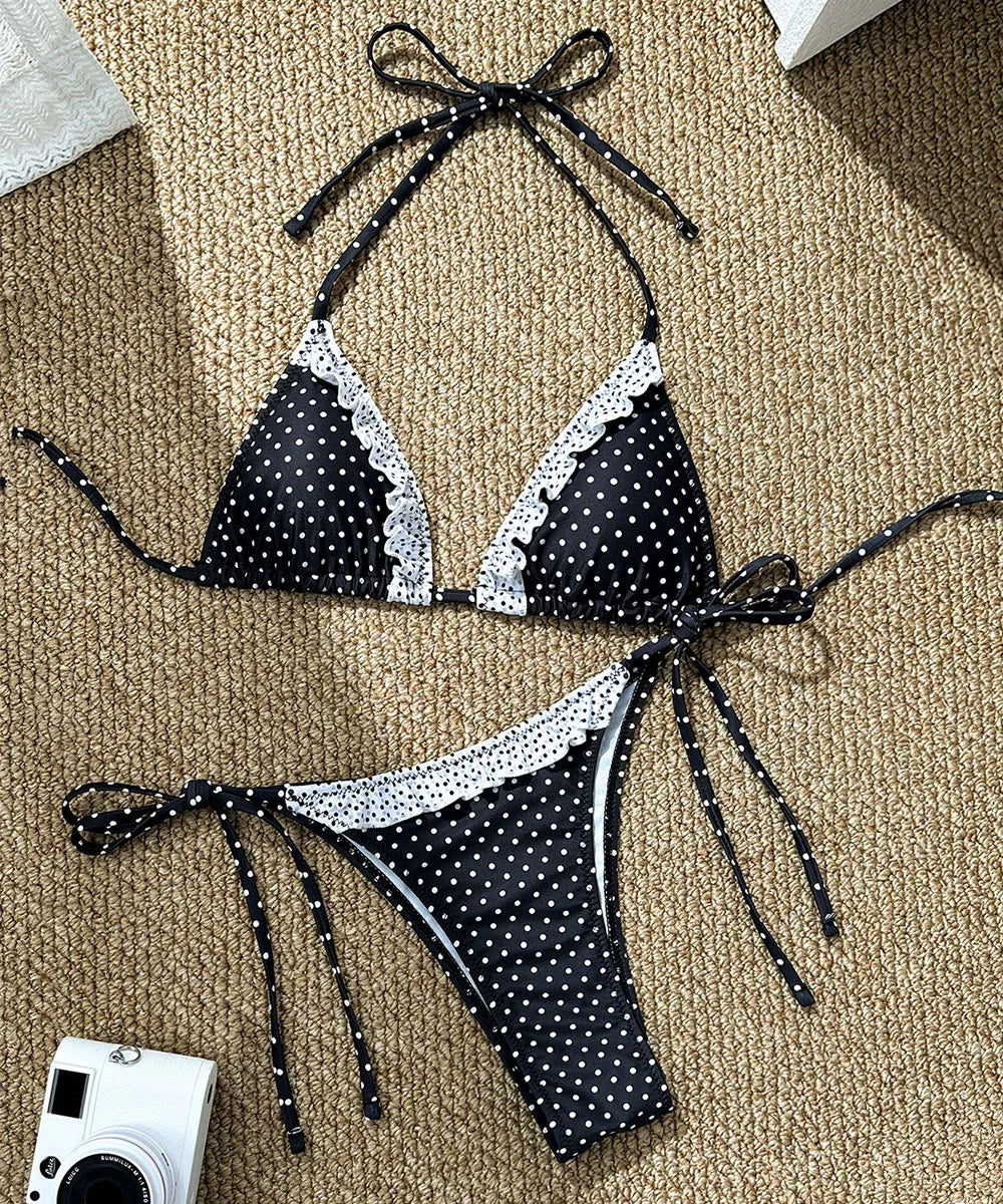 Black and white polka dot bikini set on a beige carpet with a camera in the corner.