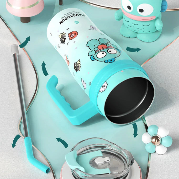 Turquoise tumbler with cartoon character design on a white surface with decorative items.