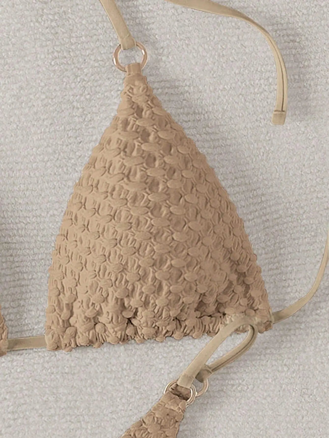 Beige textured bikini top on a light gray background