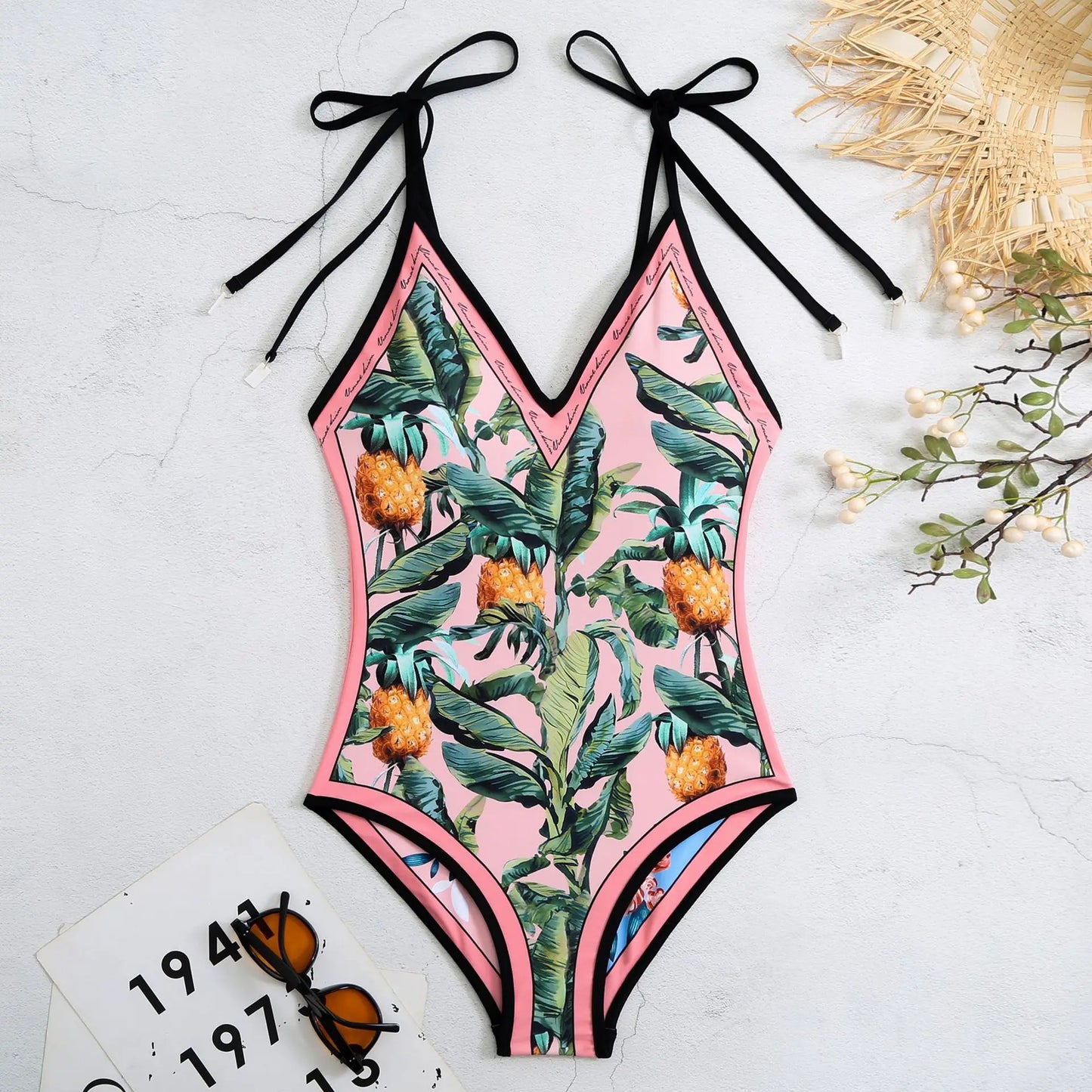 One-piece swimsuit with tropical print on a light background