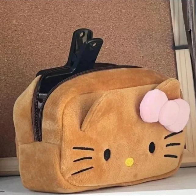 Plush cat-shaped pouch with pink bow on a surface