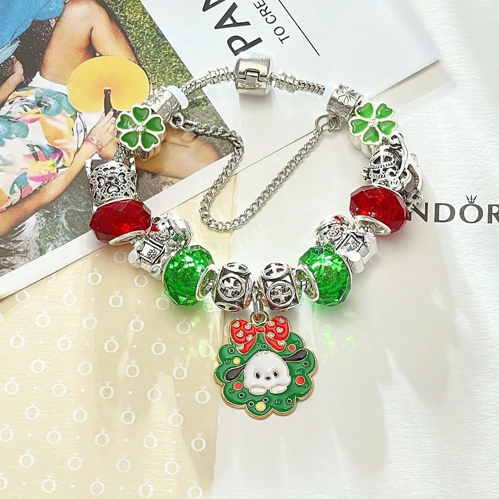 Pandora-style charm bracelet with green and red charms on a magazine background