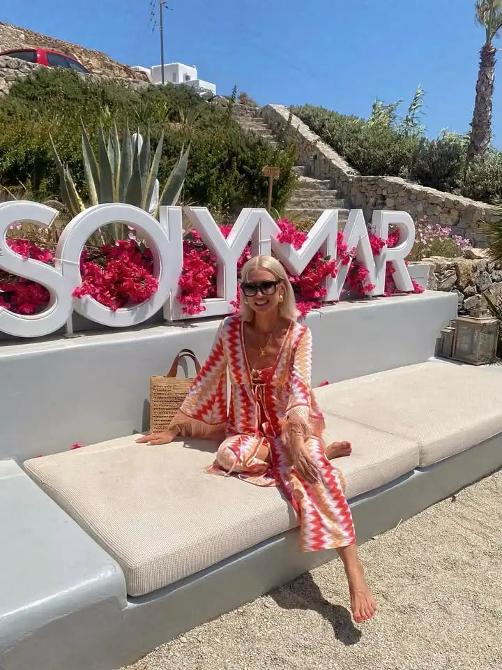 Woman sitting on a sun lounger with 'SOLYMAR' sign in the background