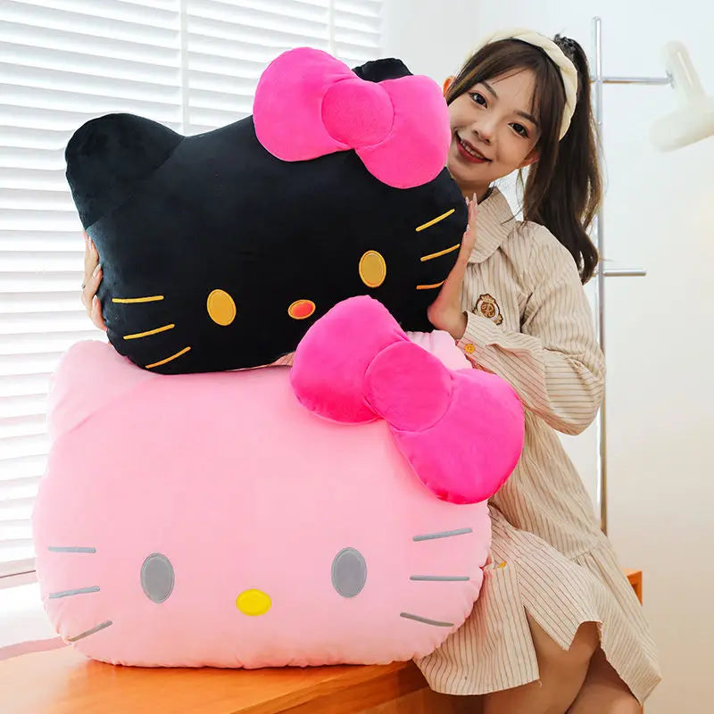 Person holding a large black and pink Hello Kitty plush toy