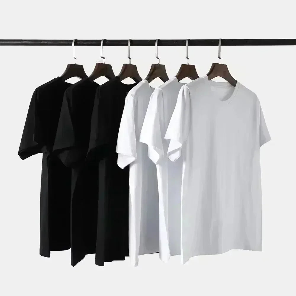 Black and white t-shirts hanging on a rack against a white background