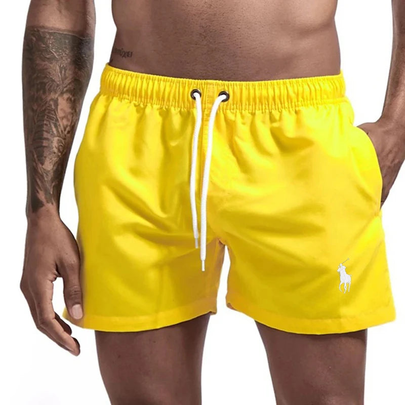 Yellow swim shorts with a brand logo on a white background