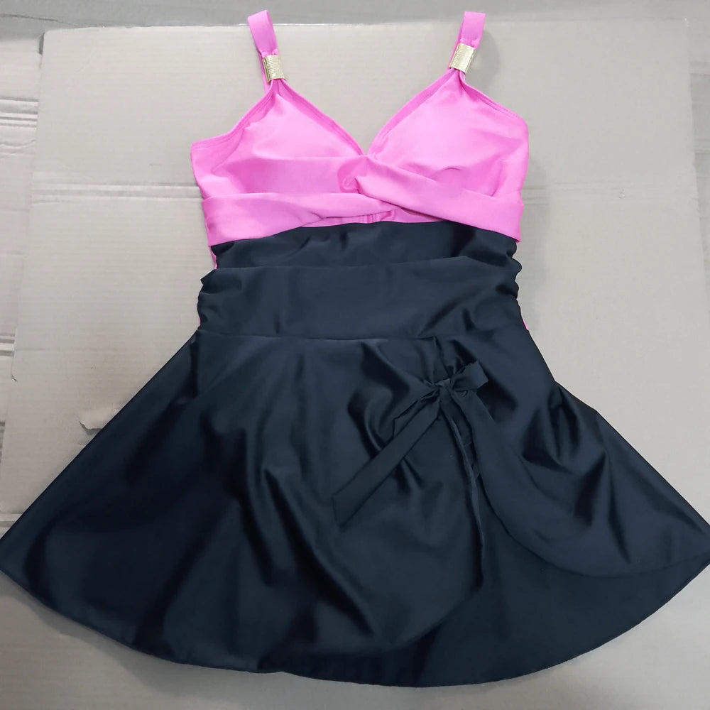 Two-tone dress with pink top and navy skirt on a light gray surface