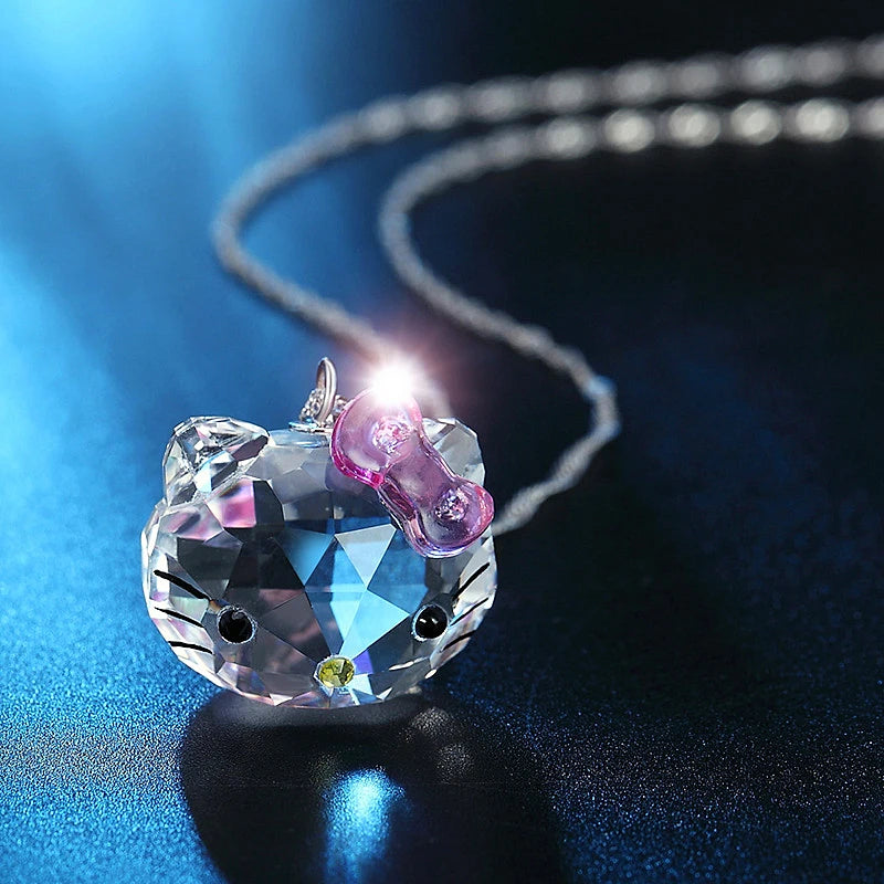 Crystal cat-shaped pendant on a chain against a dark background