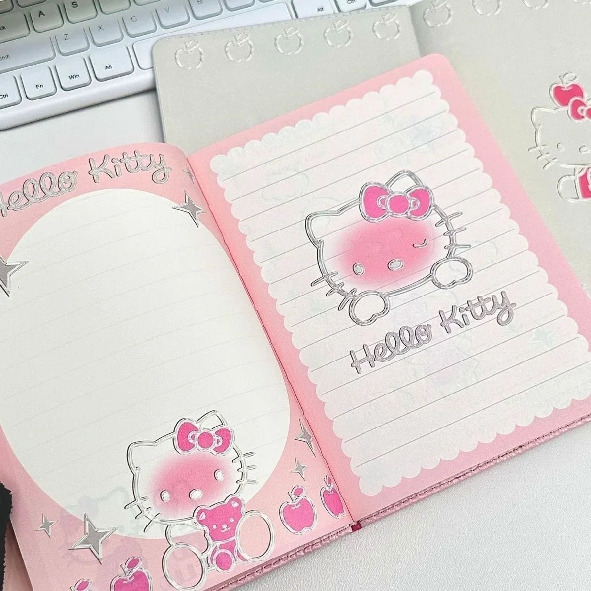 Pink notebook with Hello Kitty design on a white surface