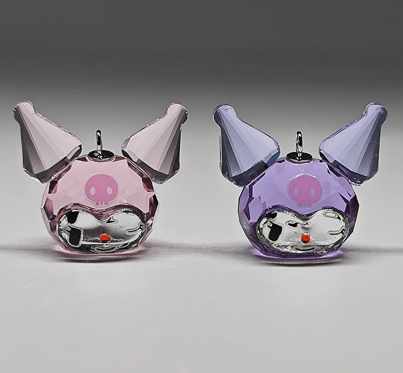 Two colorful glass figurines with a pink and purple design on a gray background