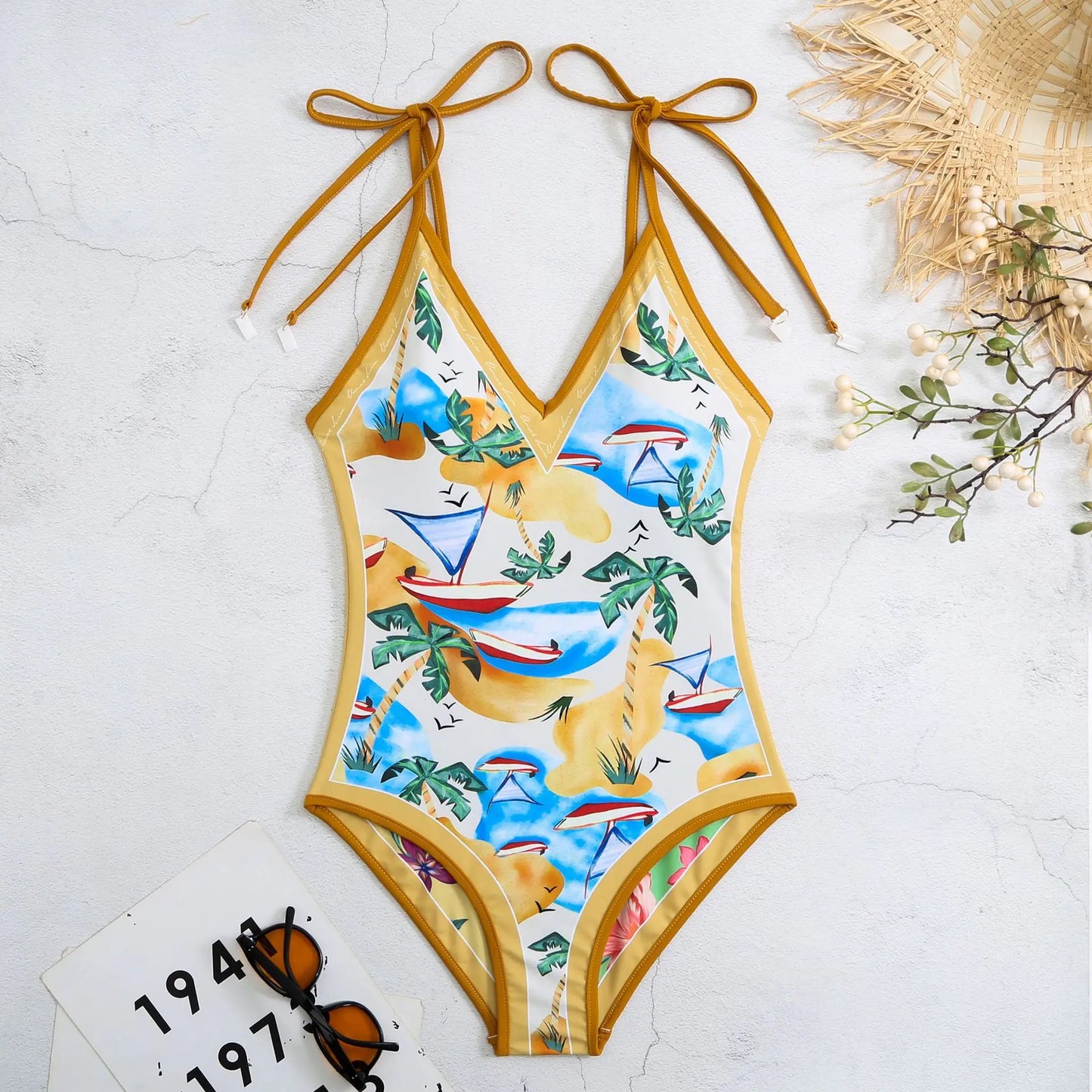 One-piece swimsuit with tropical pattern on a light background