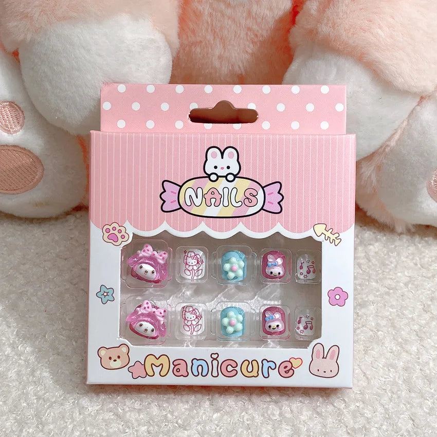 Box of cartoon-themed false nails with a pink and white polka dot design on a soft surface.