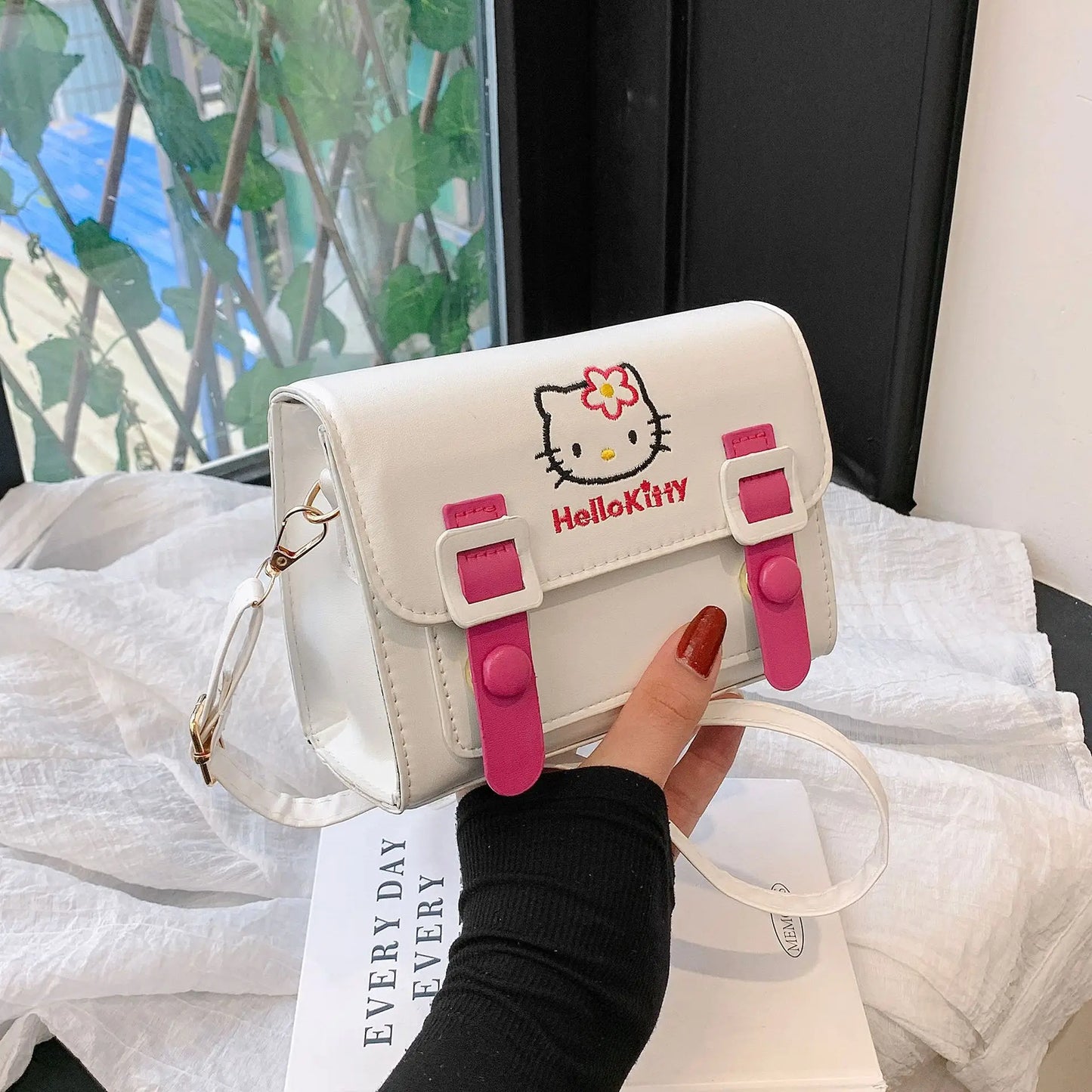 Hello Kitty handbag held by a person with a blurred background