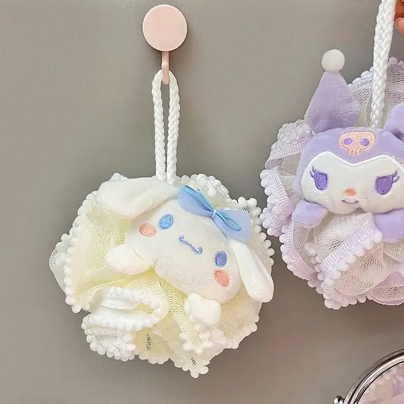 Two kitty bath scrubber plush toys attached to bath poufs against a neutral background
