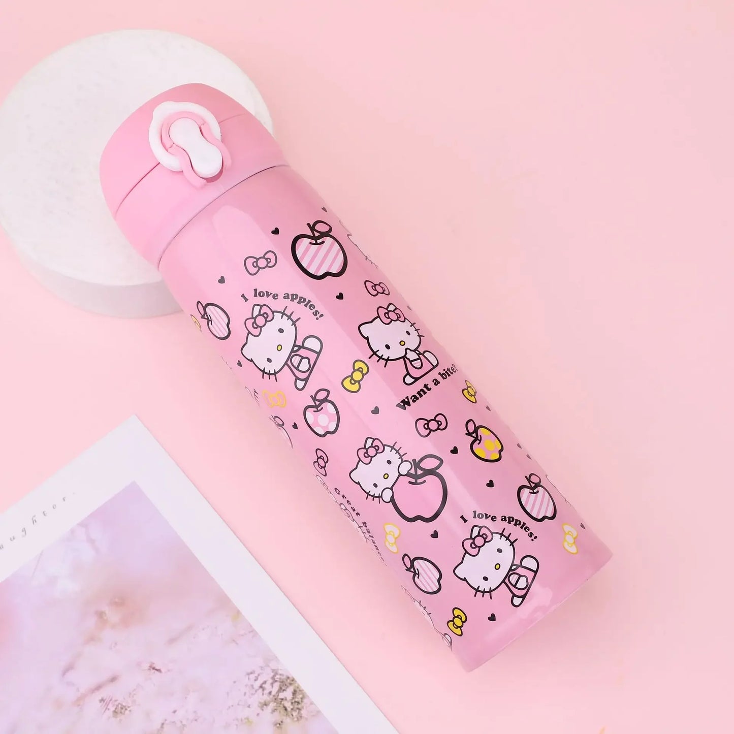 Pink water bottle with Hello Kitty design on a pink background