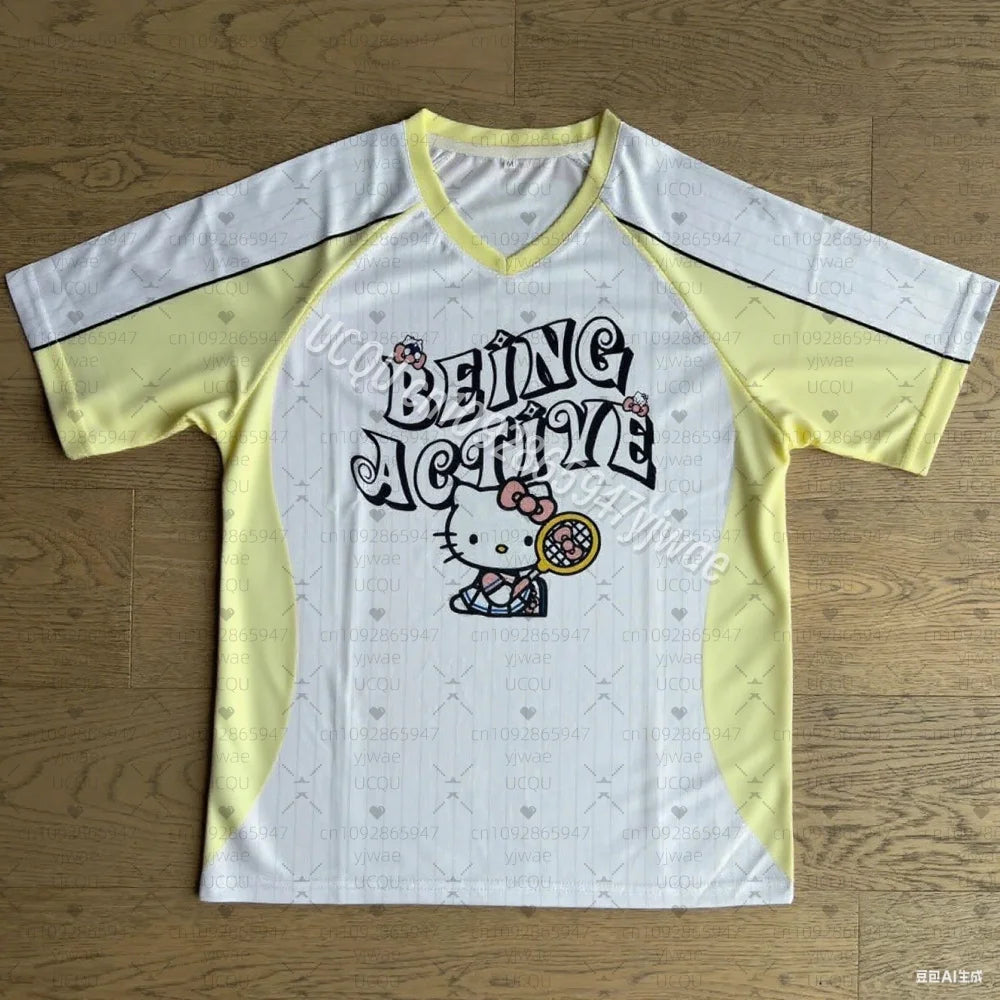 White and yellow sports jersey with 'Being Active' text and Hello Kitty graphic on a wooden floor.