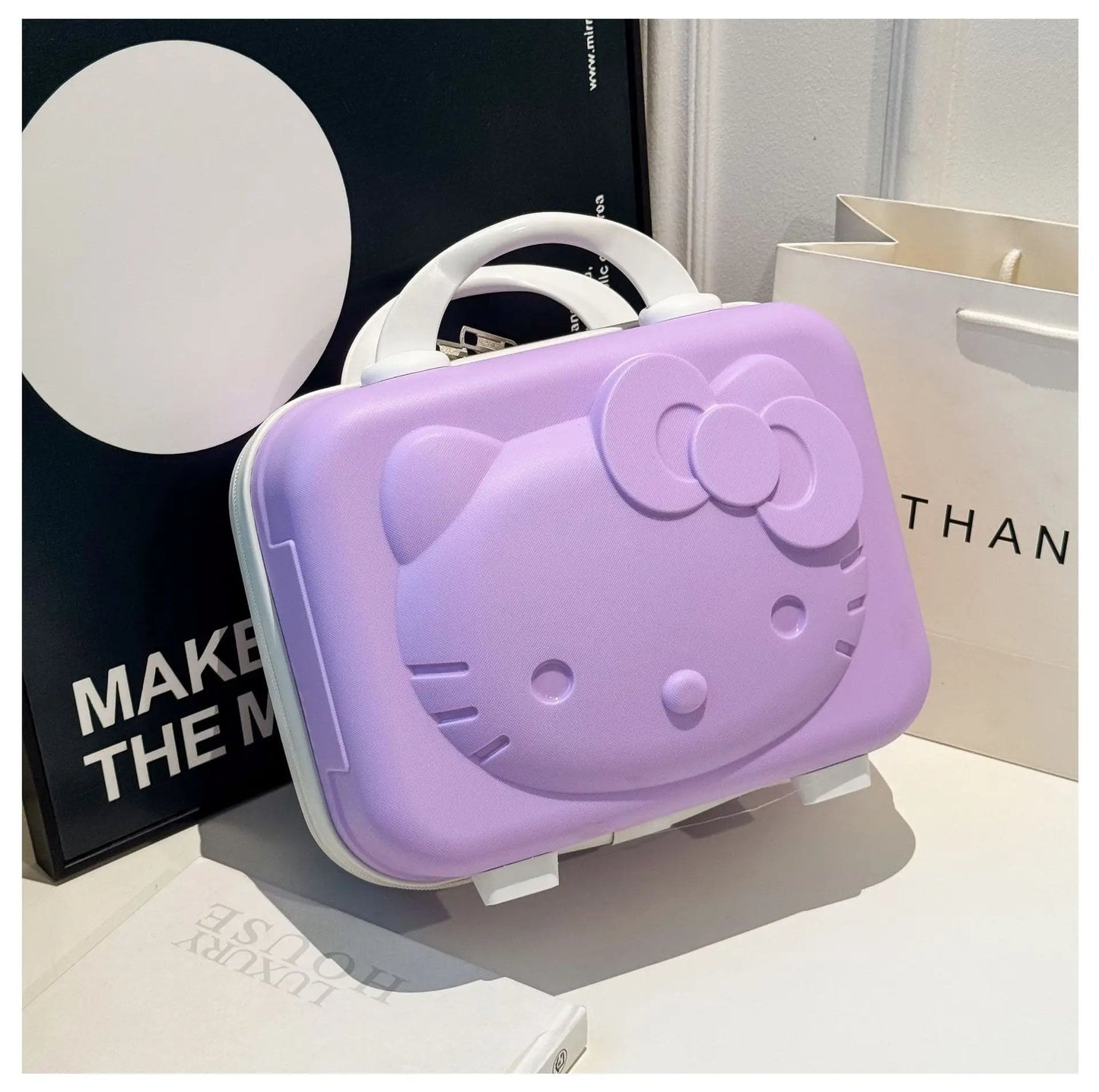 Purple Hello Kitty phone stand on a white surface with a blurred background