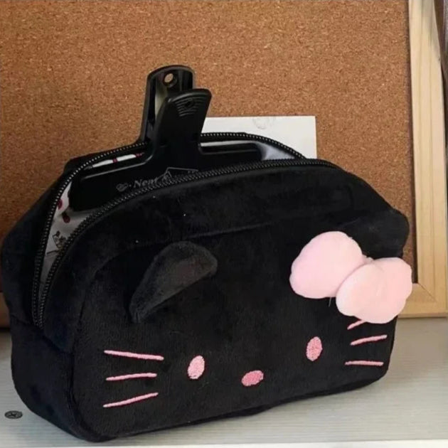 Black pouch with cat ears and pink details on a corkboard background