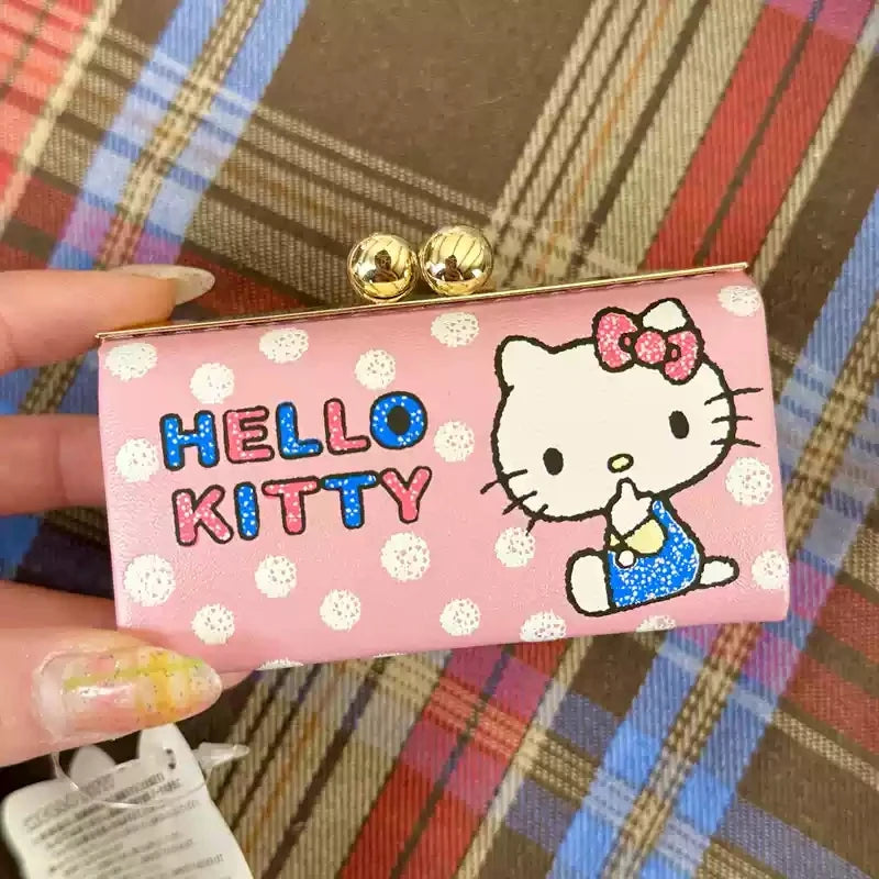 Pink Hello Kitty clutch bag held by a hand on a plaid background