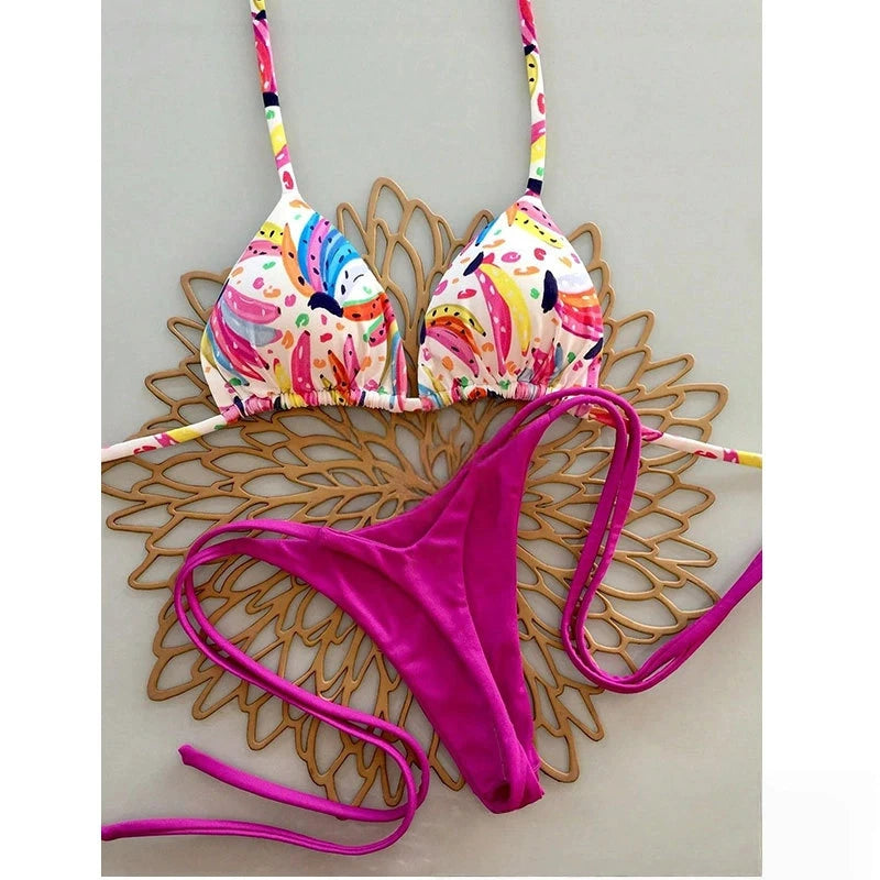 Colorful bikini top with floral design and pink bottom on a wooden surface