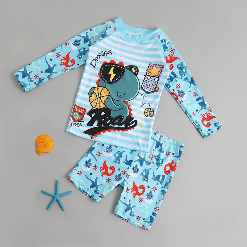 Children's dinosaur-themed pajama set with long-sleeve top and shorts on a gray background.