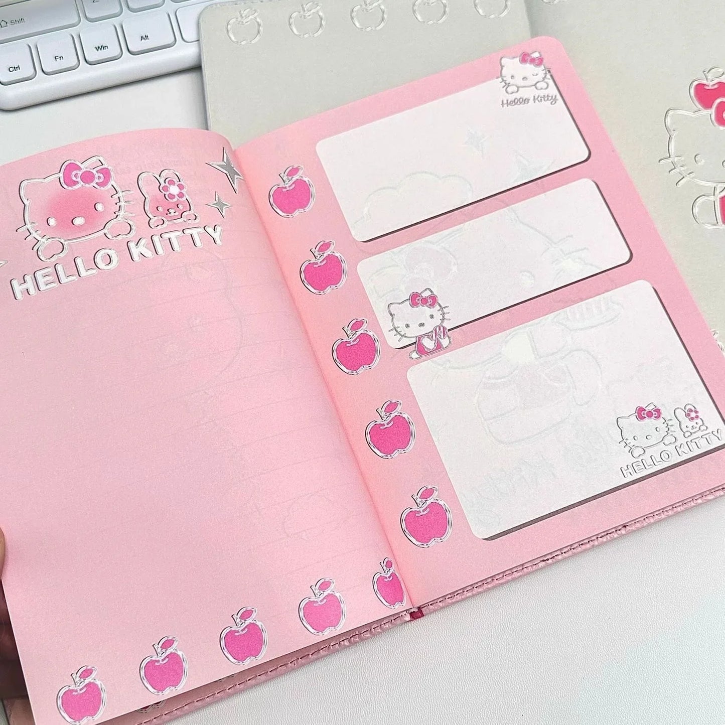Pink notebook with Hello Kitty design on a white surface