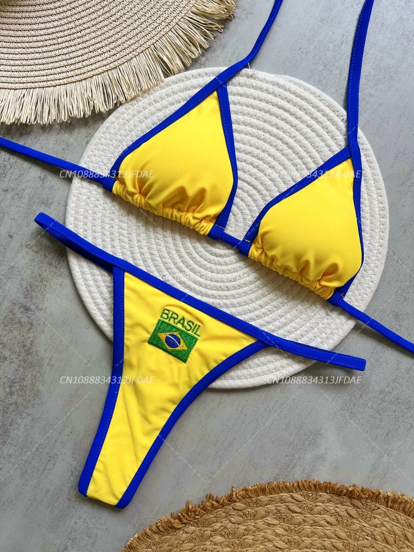 Yellow bikini with blue straps on a textured surface
