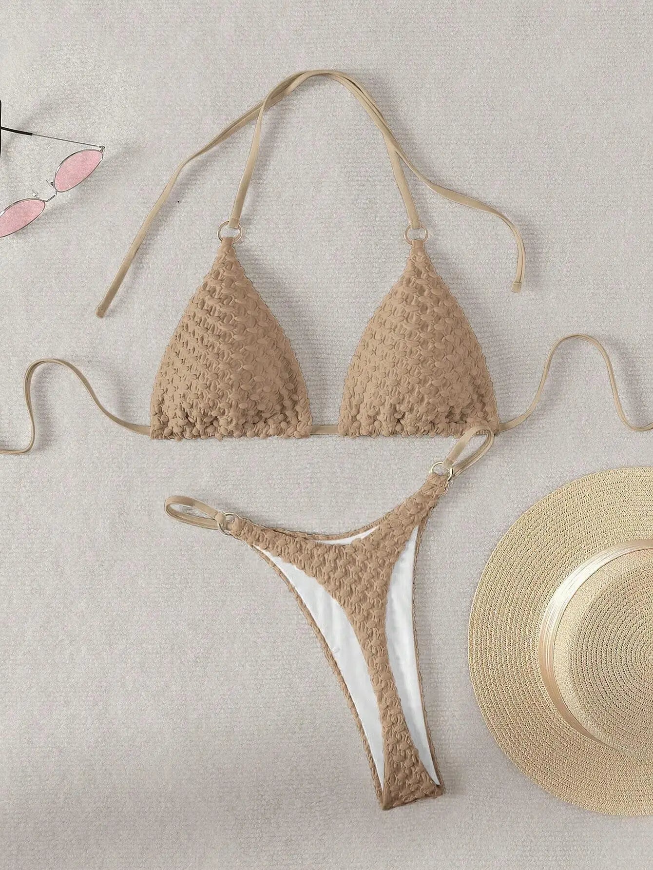 Beige crochet bikini set on a light background with a straw hat.