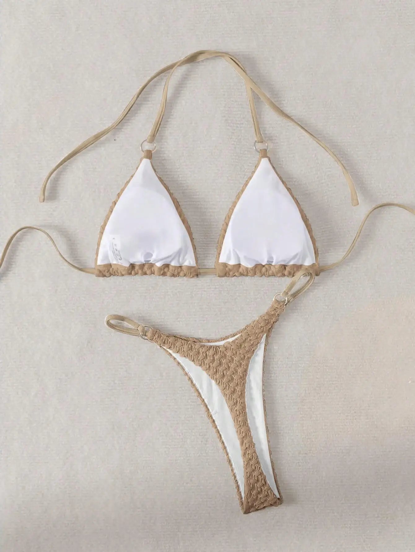 Beige and white bikini set on a beige background
