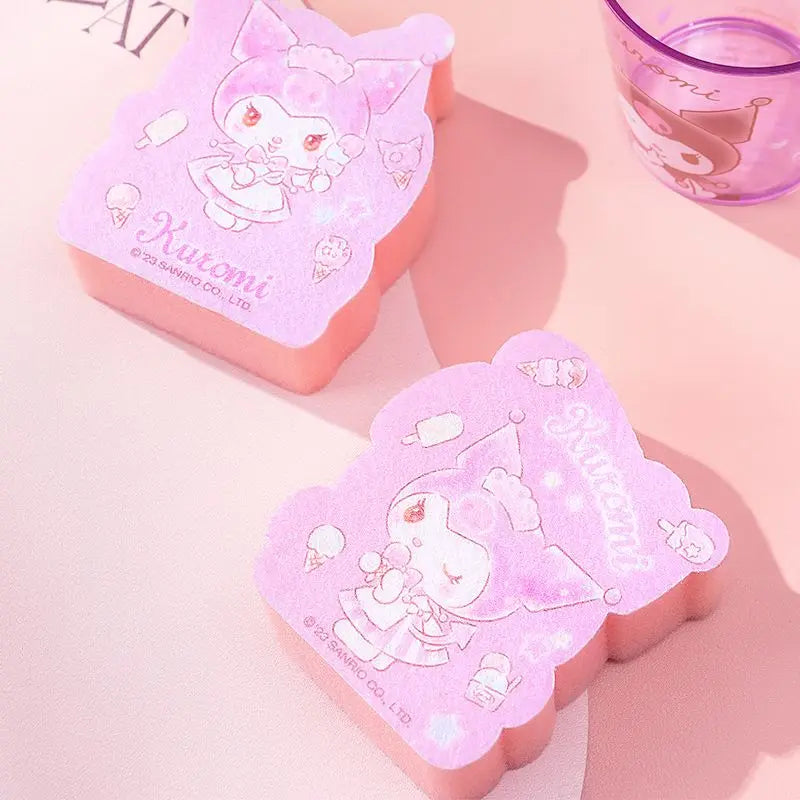 Two pink and purple rectangular items with cartoon character designs on a light pink background.