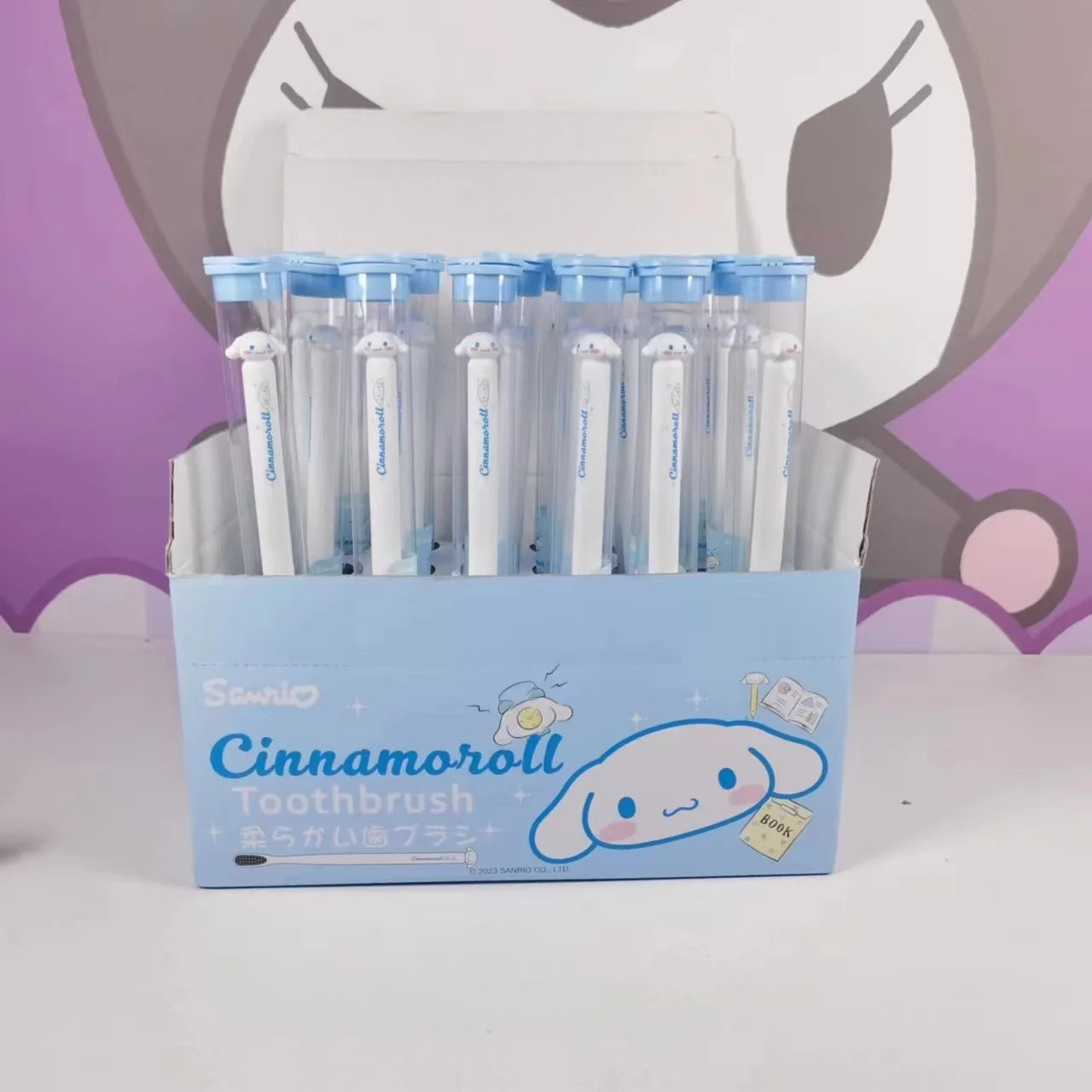 Box of Cinnamoroll-themed toothbrushes with a cartoon character in the background