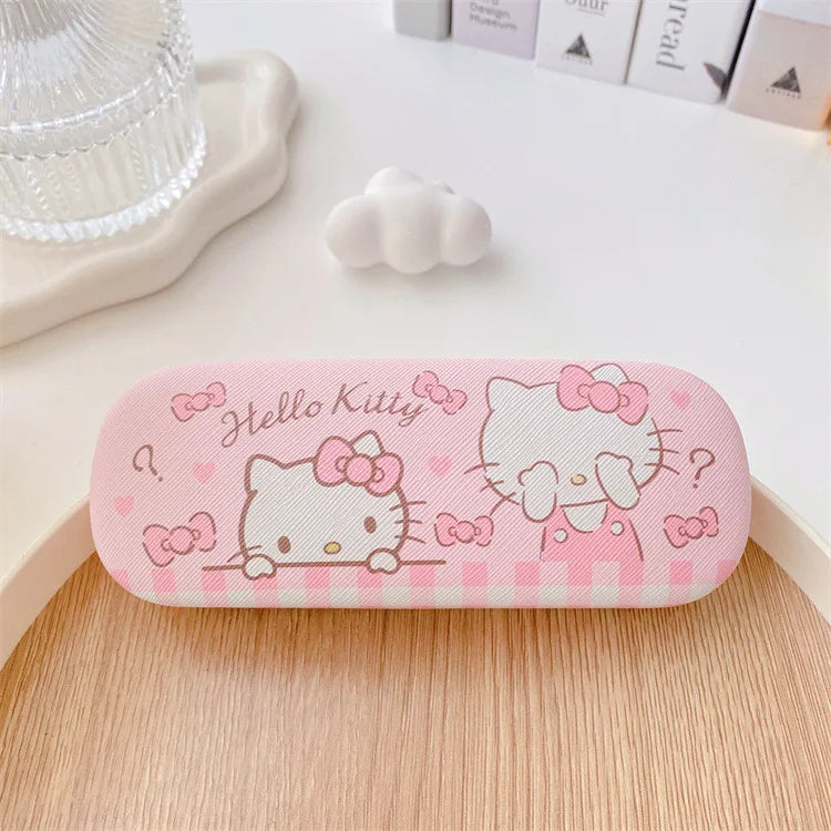 Pink 'Hello Kitty' glasses case on a wooden surface with decorative items in the background.