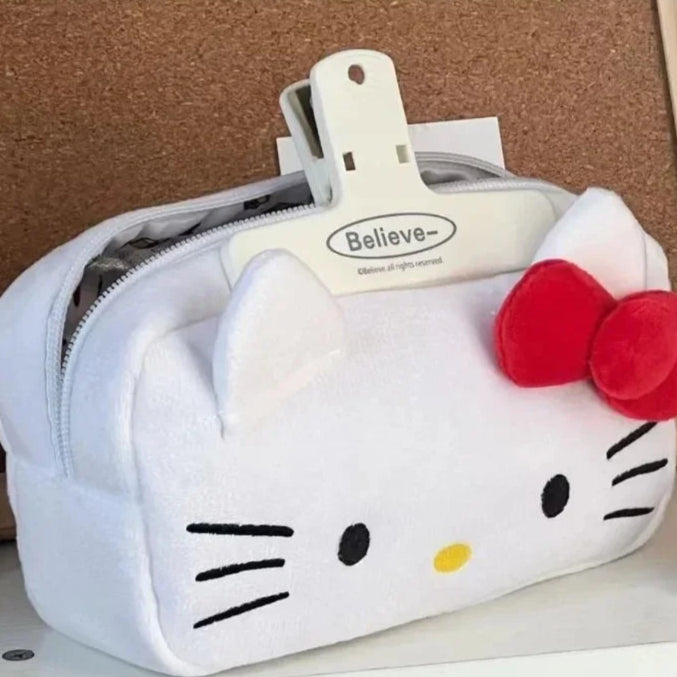 Hello Kitty-themed pouch with a red bow on a corkboard background